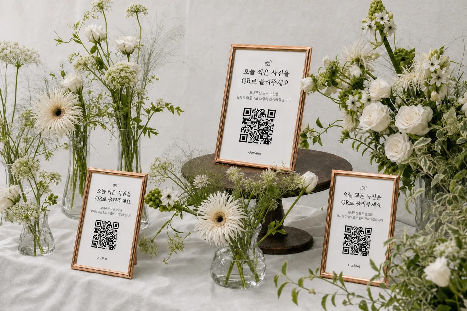 웨딩 꽃 사이에 놓인 로즈골드 아워샷 QR 액자 3개